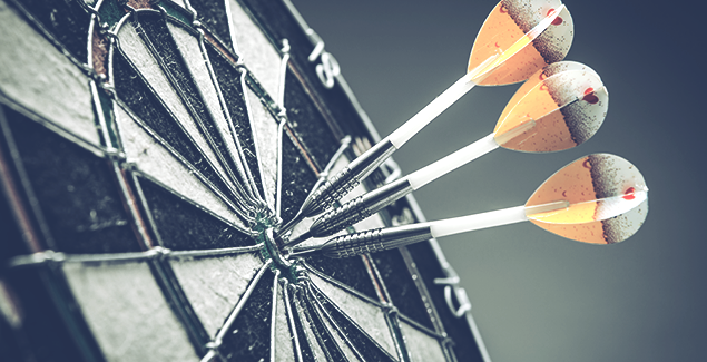 Photo of a darts board with three darts in the bulls eye